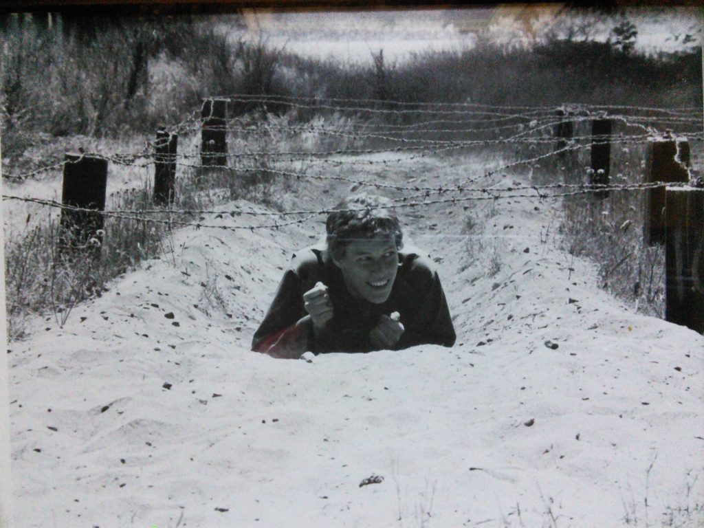 Me climbing under barbed wire